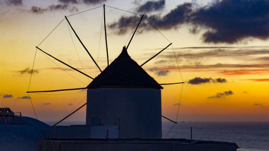 Eine Windmühle auf Santorini im Sonnenuntergang griechenland urlaub, geheimtipps griechenland, windmühle, santorini, milos